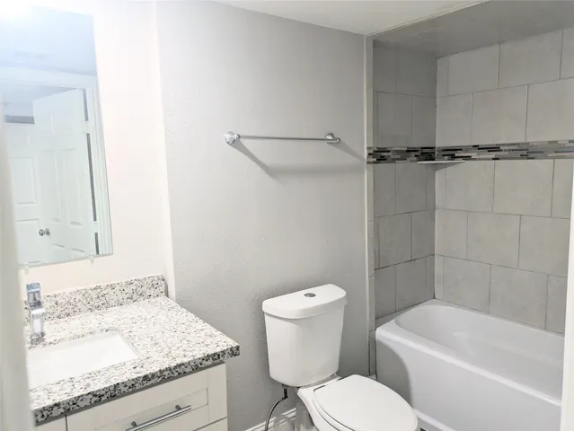 a white toilet sitting next to a bath tub