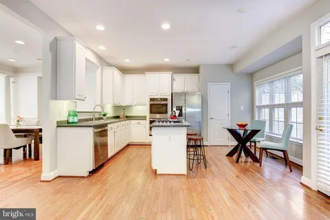 a kitchen with a table chairs refrigerator and cabinets