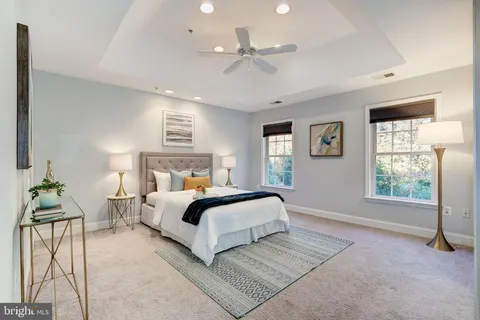 a spacious bedroom with a large bed and a chandelier