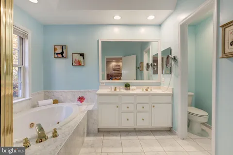 a bathroom with a tub sink and mirror