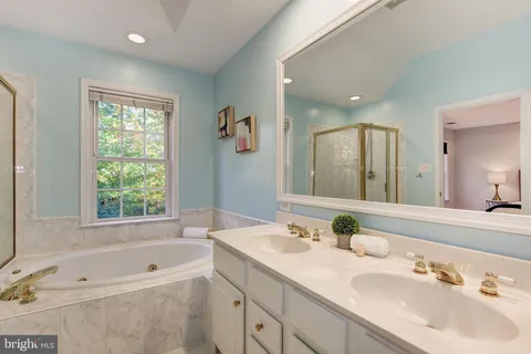 a bathroom with a tub a sink and mirror