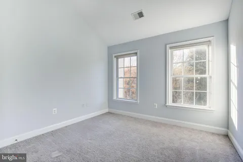 an empty room with windows and closet