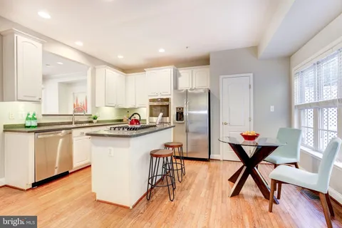 a open kitchen with stainless steel appliances granite countertop a refrigerator and a stove top oven