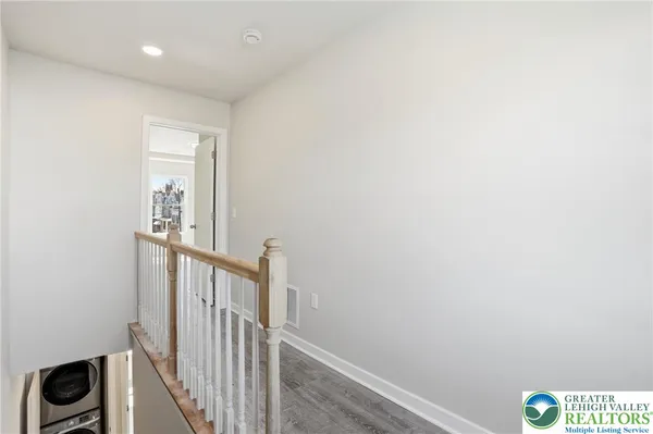 a view of hallway with stairs and wooden floor