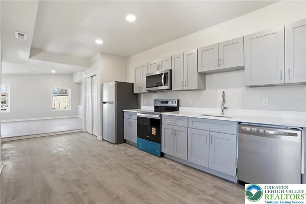 a kitchen with granite countertop a refrigerator stove top oven and sink