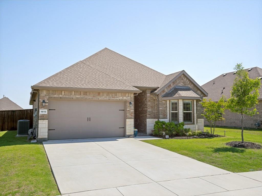 1612 Reed Drive Krum, TX 76249 - Photo 2 of 25 Brick and stone facade featuring a bay window, a two-car garage, and a concrete driveway