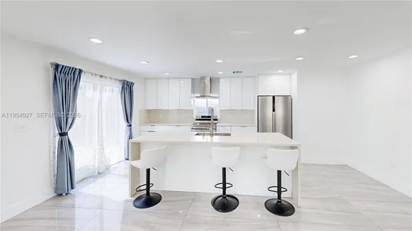 a kitchen with stainless steel appliances kitchen island hardwood floor and center island