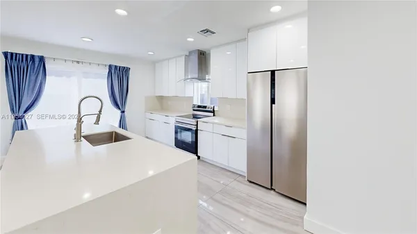 a kitchen with refrigerator cabinets and a sink