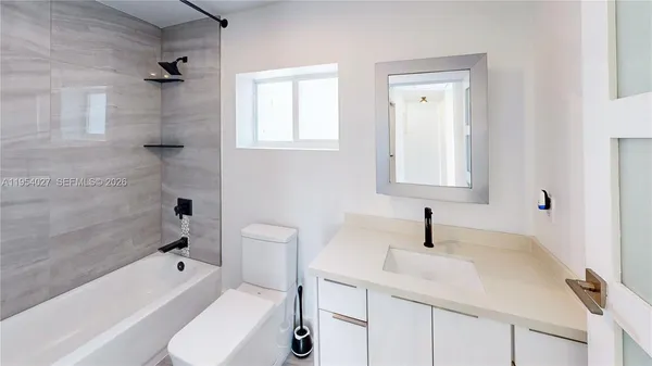 a bathroom with a sink toilet vanity and bathtub