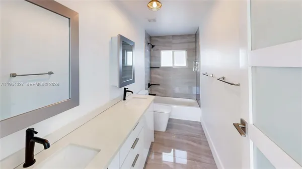 a bathroom with a tub sink and mirror