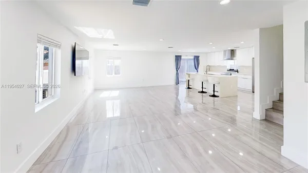 a view of a living room hardwood floor and a kitchen