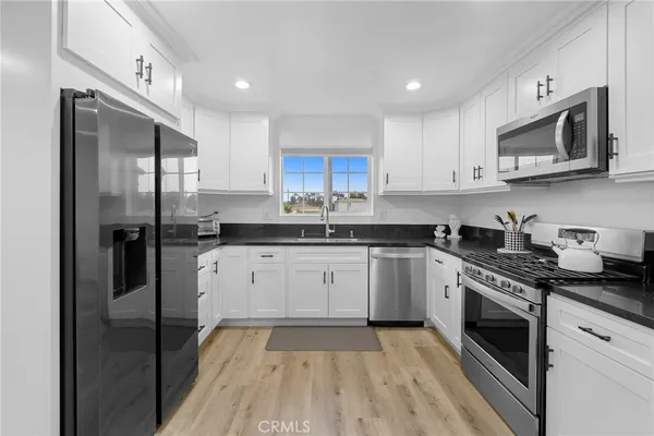 a kitchen with stainless steel appliances granite countertop a stove a sink and a refrigerator