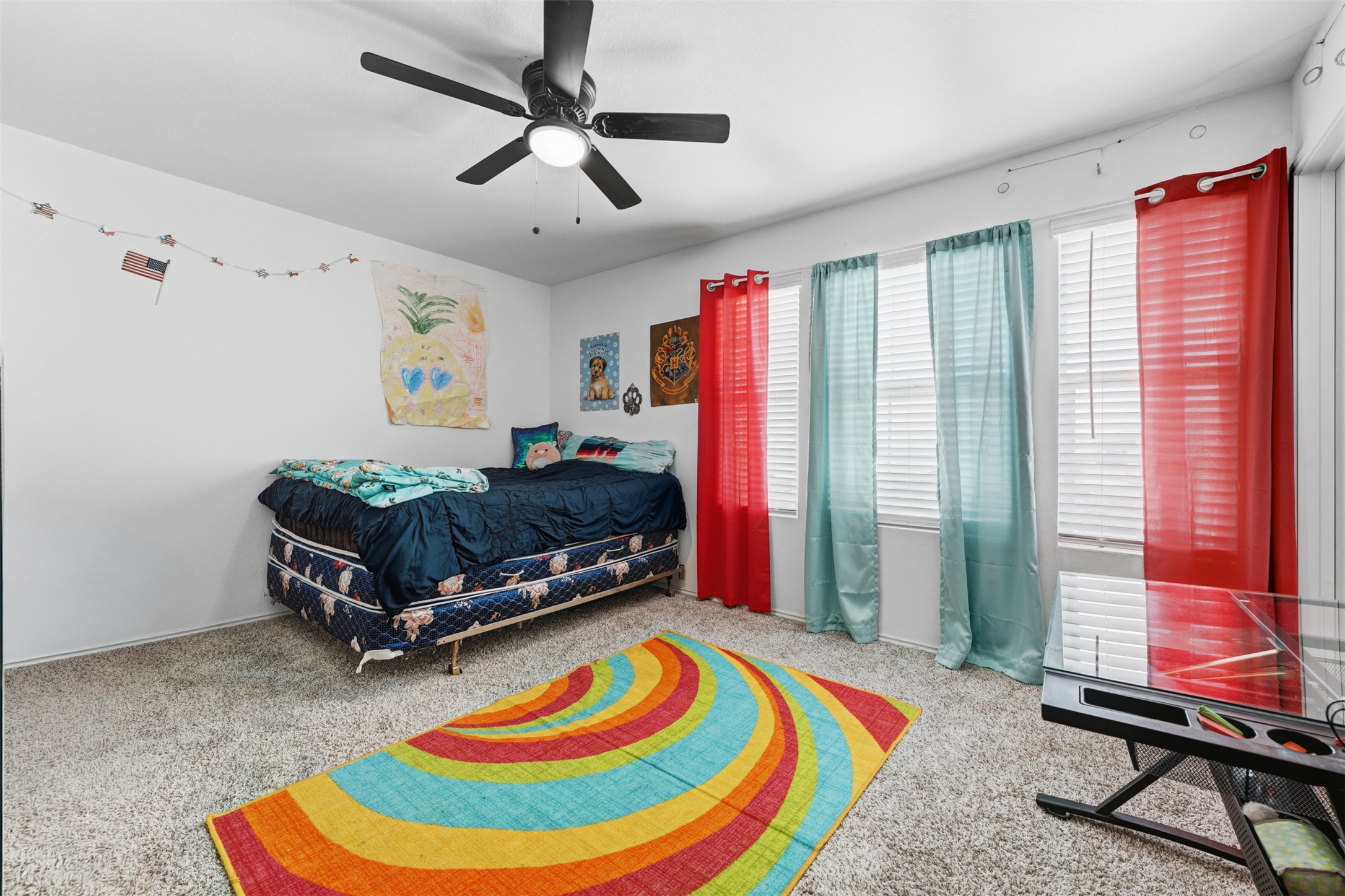 413 Perfect World Loop Jarrell, TX 76537 - Photo 26 of 39 A comfortable bedroom with soft carpet, natural light, and a cooling ceiling fan.