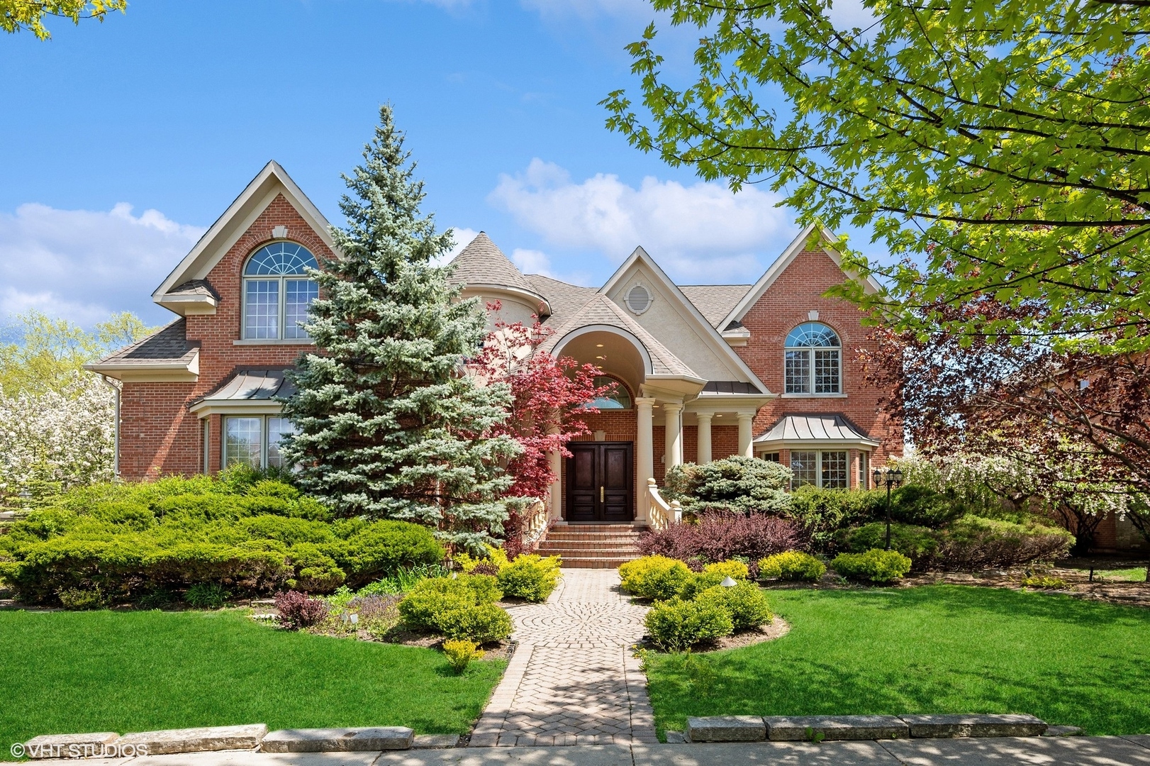 a front view of a house with a yard and potted plants