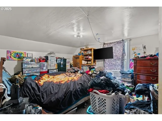 a bedroom with furniture and a flat screen tv