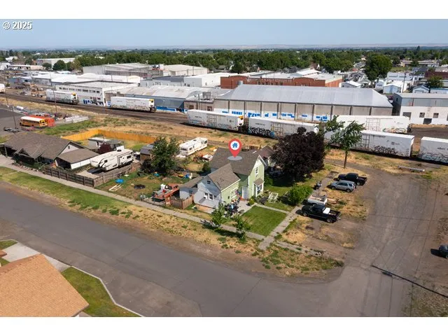 an aerial view of residential houses with outdoor space and street view