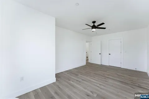 a view of a room with wooden floor and a ceiling fan