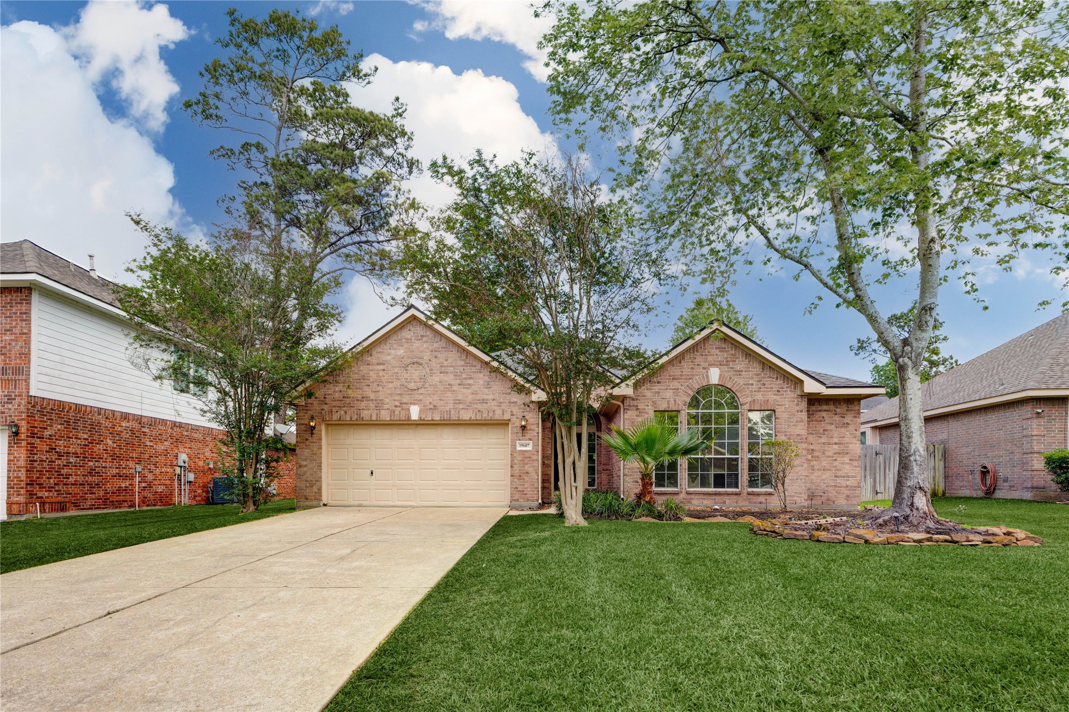 Beautiful front elevation with mature trees and manicured landscaping.