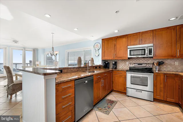 a kitchen with stainless steel appliances a stove microwave and sink