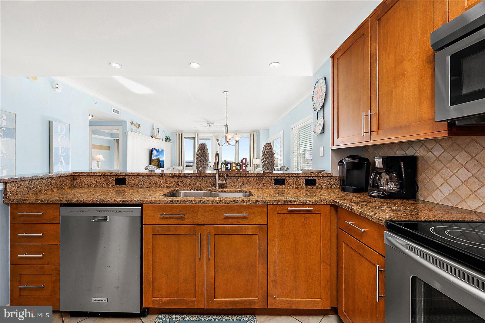 8 60th Street, Unit 902 Ocean City, MD 21842 - Photo 18 of 67 a kitchen with stainless steel appliances granite countertop a stove a sink and a microwave