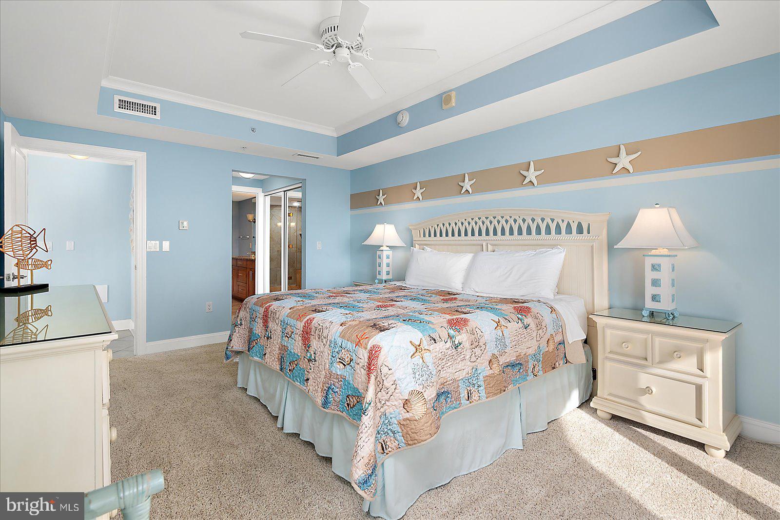 8 60th Street, Unit 902 Ocean City, MD 21842 - Photo 29 of 67 a spacious bedroom with a bed a mirror and lamp