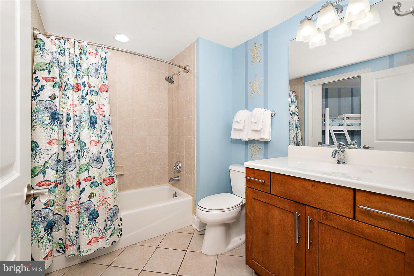 8 60th Street, Unit 902 Ocean City, MD 21842 - Photo 42 of 67 a bathroom with a sink a toilet and shower curtain