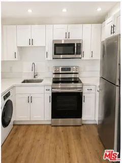 a kitchen with stainless steel appliances a stove a sink and a microwave