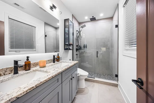 a bathroom with a sink a toilet and shower