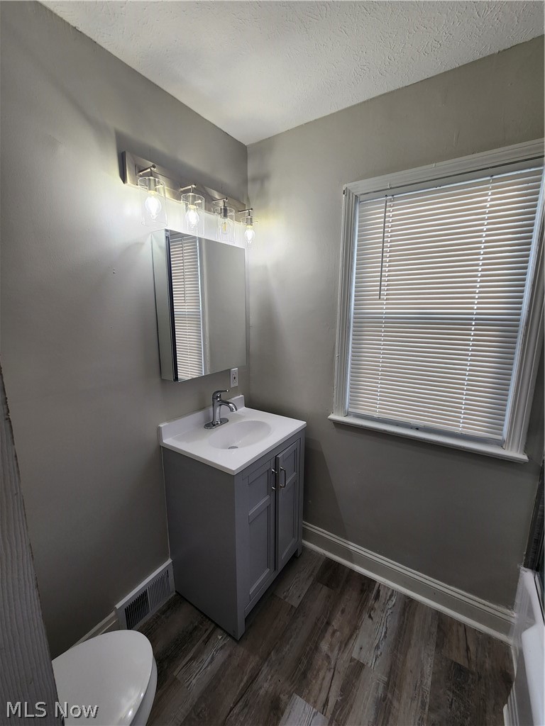 2199 North Taylor Road Cleveland Heights, OH 44112 - Photo 15 of 19 Bathroom with wood-type flooring, vanity, toilet, and a textured ceiling