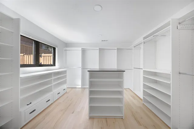 a view of walk in closet with empty racks