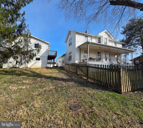 a view of a house with a small yard and wooden fence
