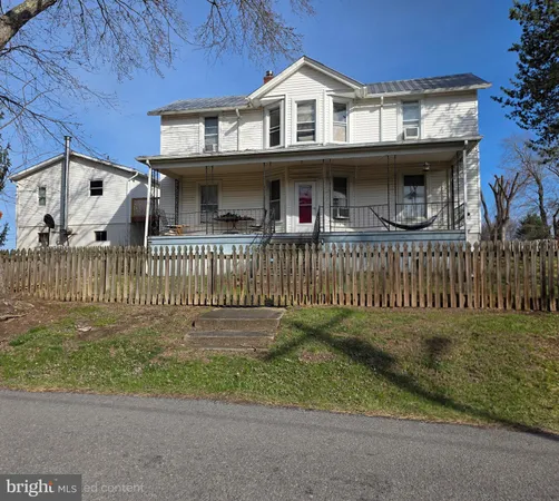 a view of a house with a small yard and wooden fence