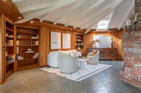 a living room with furniture a rug and a bookshelf