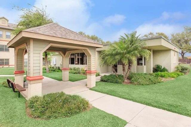 a front view of a house with a yard and potted plants