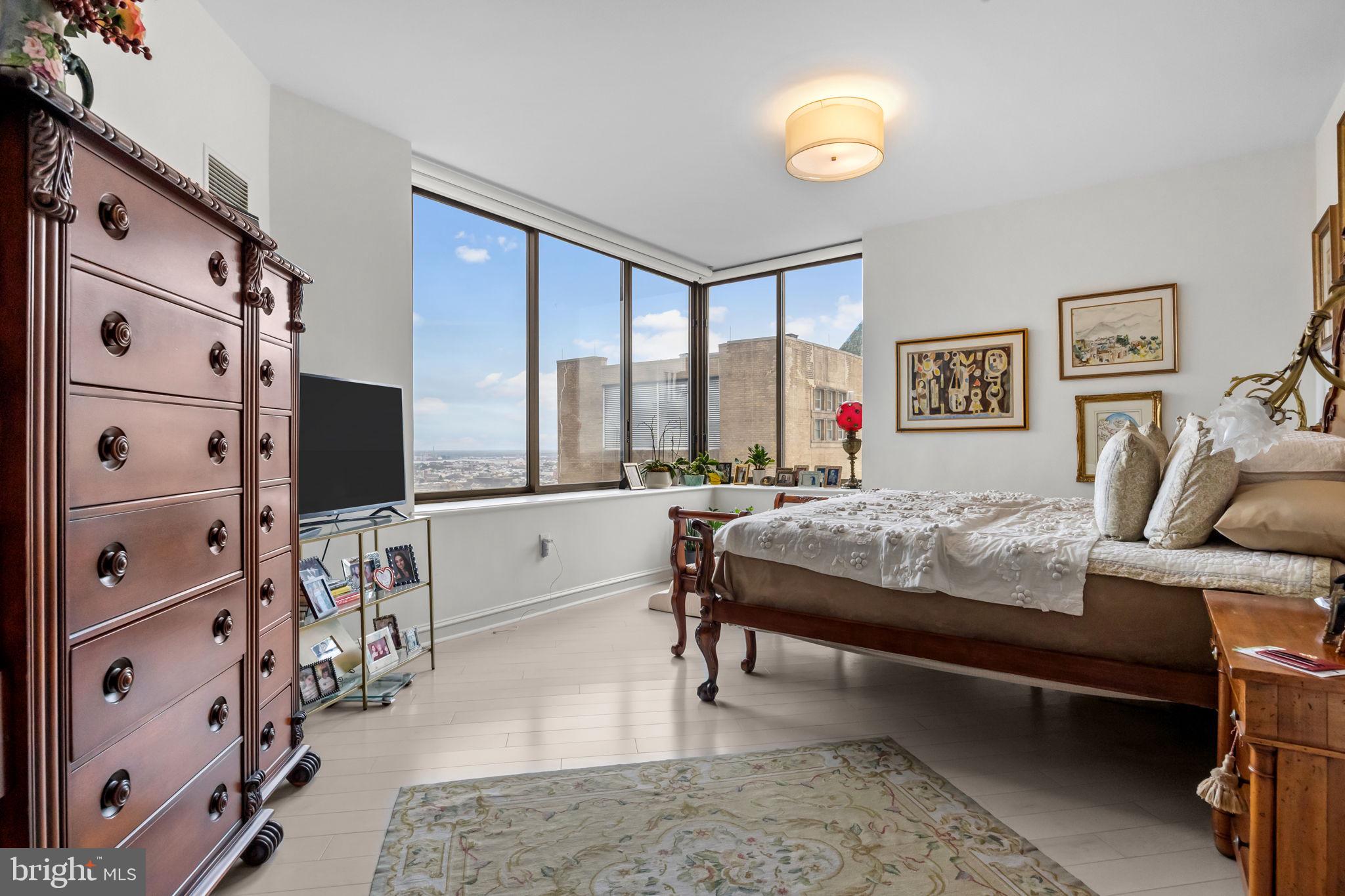 202 West Rittenhouse Square, Unit 2608 Philadelphia, PA 19103 - Photo 15 of 35 a bedroom with a bed and a flat tv screen on dresser