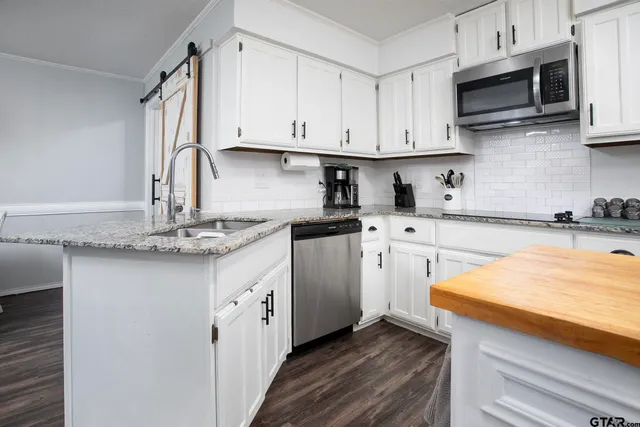 a kitchen with stainless steel appliances granite countertop a sink stove and microwave