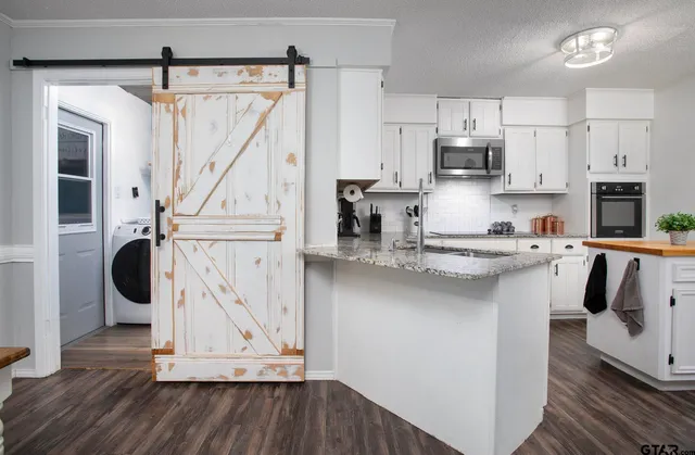 a kitchen with a sink cabinets and wooden floor