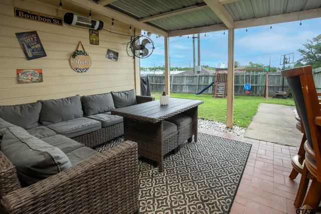 a view of a patio with couches and table and chairs with wooden fence