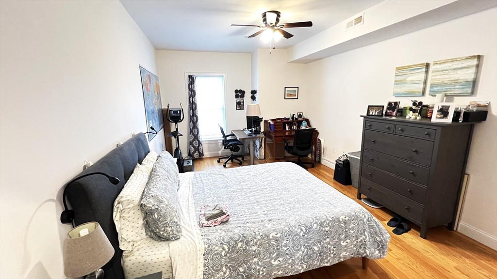 489 Main Street, Unit A Stoneham, MA 02180 - Photo 8 of 19 a bed room with a bed and a dresser