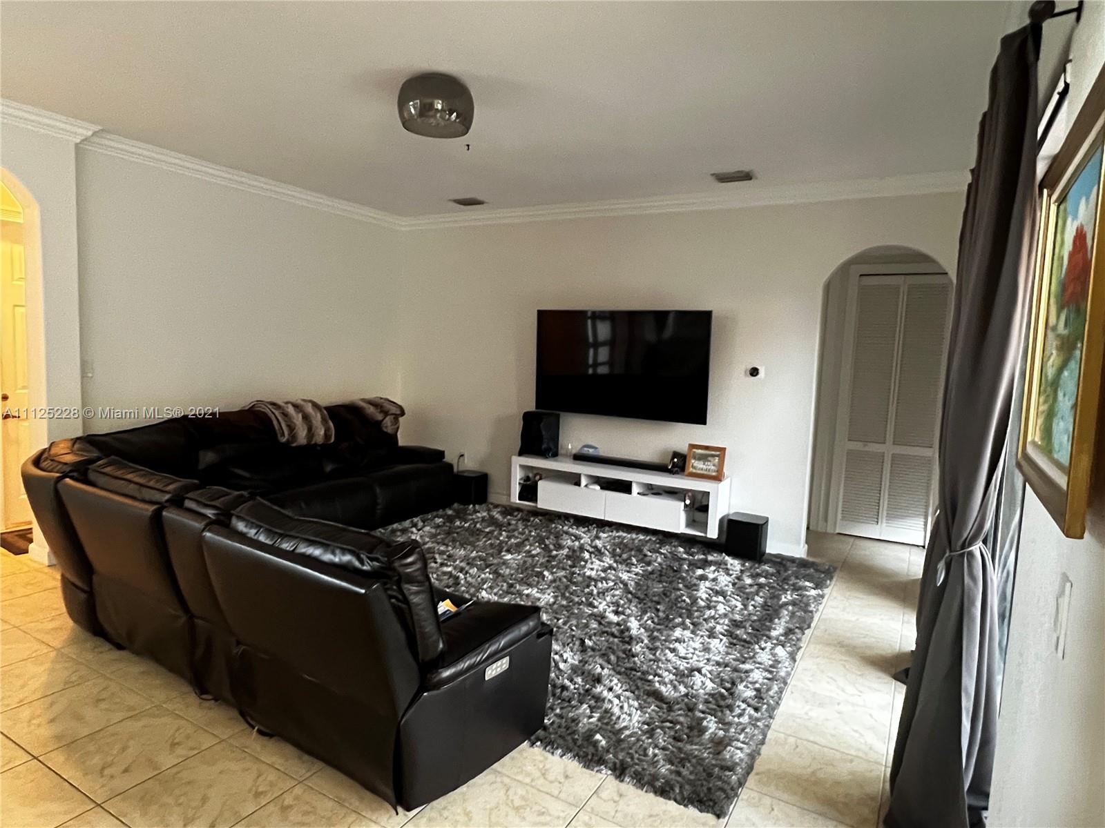 7985 Southwest 195th Street Cutler Bay, FL 33157 - Photo 2 of 16 a living room with furniture and a flat screen tv