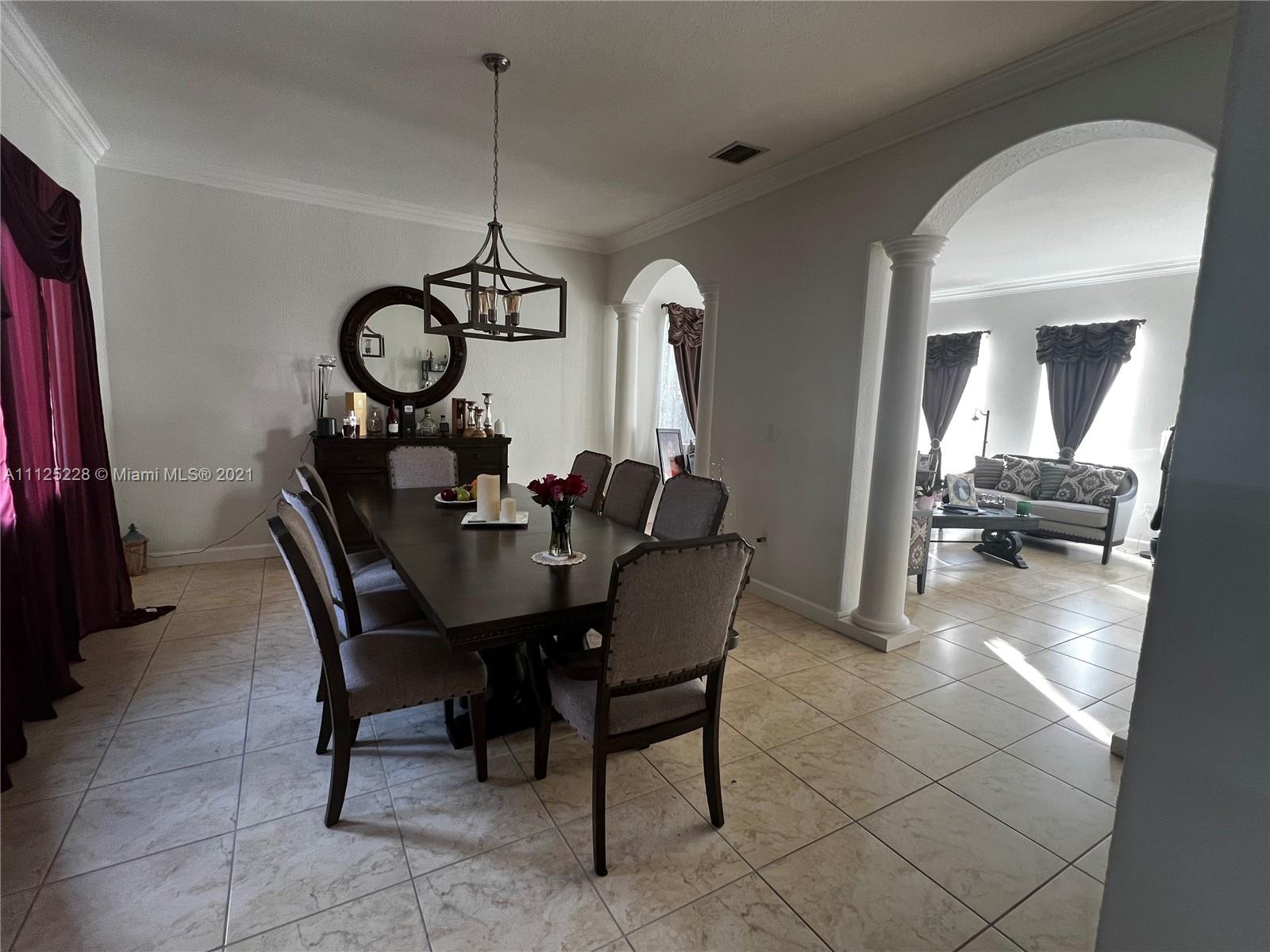 7985 Southwest 195th Street Cutler Bay, FL 33157 - Photo 6 of 16 a dining room with furniture and a mirror