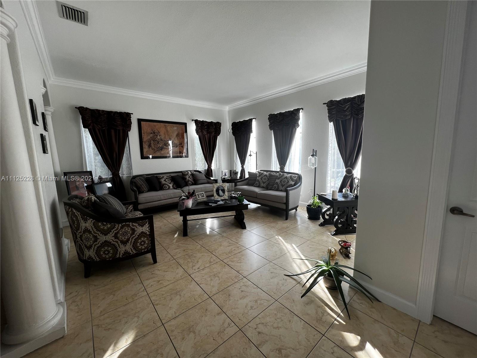7985 Southwest 195th Street Cutler Bay, FL 33157 - Photo 8 of 16 a living room with furniture and a flat screen tv