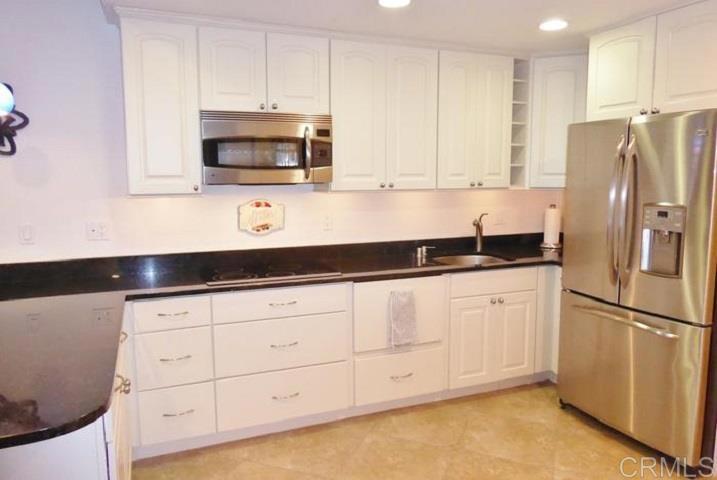 2005 Costa Del Mar Road, Unit 624 Carlsbad, CA 92009 - Photo 12 of 24 a kitchen with granite countertop white cabinets and stainless steel appliances