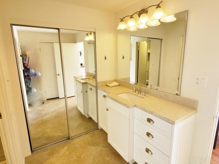 2005 Costa Del Mar Road, Unit 624 Carlsbad, CA 92009 - Photo 20 of 24 a bathroom with a granite countertop sink mirror and a shower