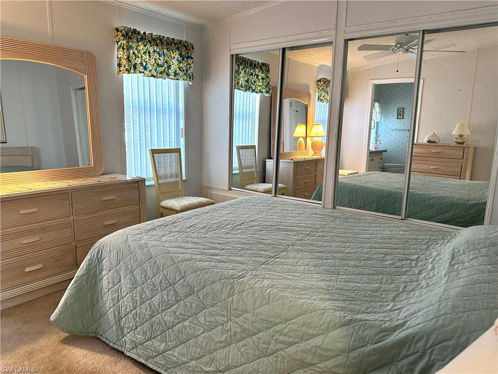 4680 Slash Pine Way West Estero, FL 33928 - Photo 13 of 20 a large bed sitting in a bedroom next to a window and chandelier