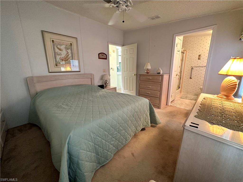4680 Slash Pine Way West Estero, FL 33928 - Photo 15 of 20 a bedroom with a bed and a chandelier