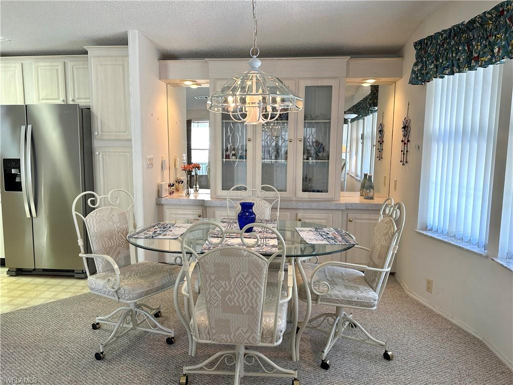 4680 Slash Pine Way West Estero, FL 33928 - Photo 7 of 20 a view of a dining room with furniture and chandelier