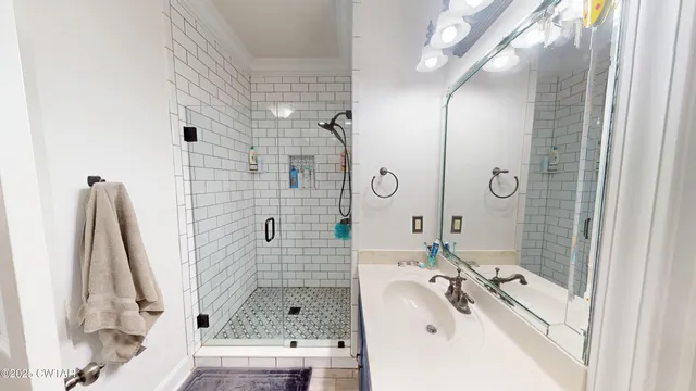 a bathroom with a sink a mirror and shower