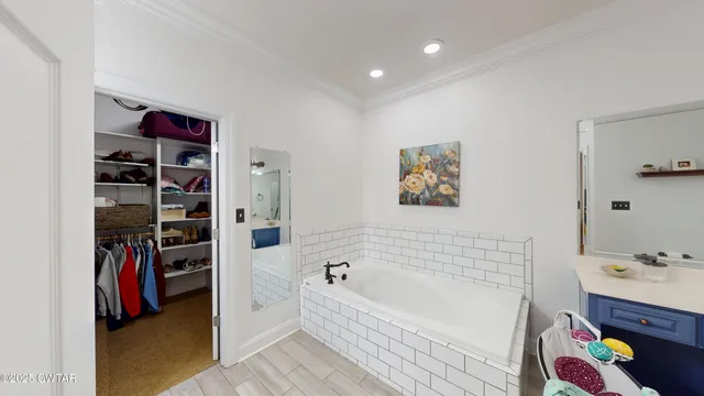 a bathroom with a bathtub and a walk in closet