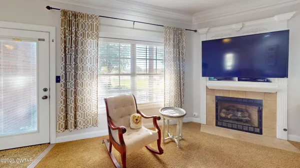 a living room with furniture a flat screen tv and a fireplace